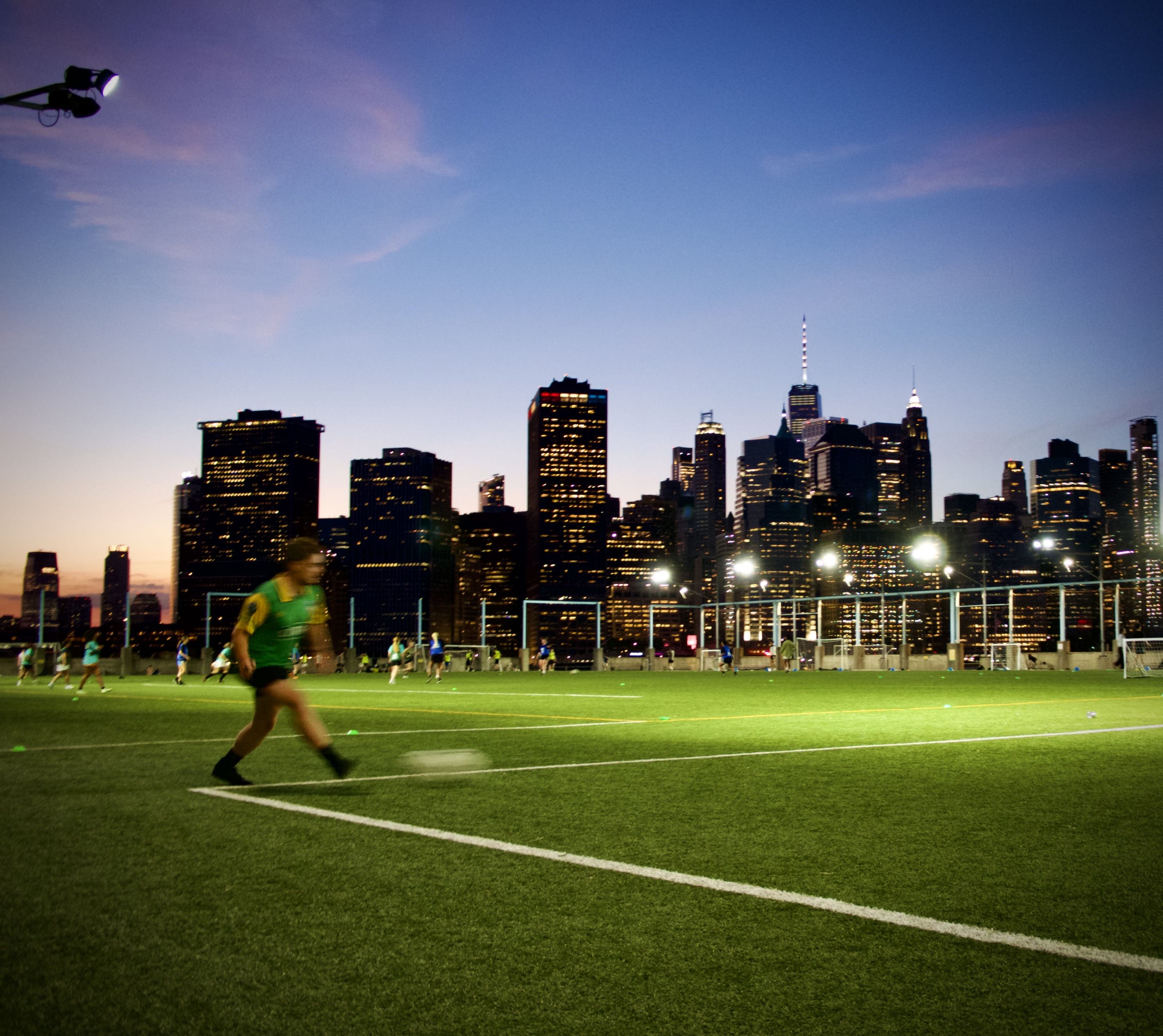 Pickup soccer game at sunset with NYC skyline